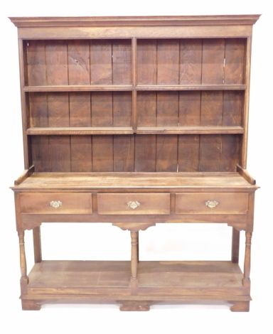 An oak dresser in 18thC style, the top with a moulded cornice above two plate shelves, the base with an arrangement of three frieze drawers on turned supports, with pot board, on bracket feet, 190cm high, 157cm wide.