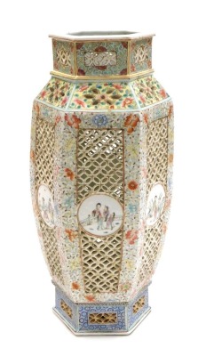 A Qing dynasty late 19thC Chinese famille rose pierced porcelain lantern, of shouldered hexagonal form, with reticulated and painted decoration, having circular reserves with figures, on a floral ground, later converted to a table lamp, bears traces of a