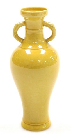 A Chinese yellow ground porcelain vase, of twin handled slender baluster form, 14cm high.