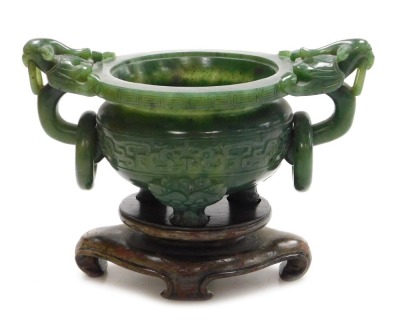 A Chinese spinach jade censer, with twin bird head and ring handles, carved with a band of stylised dragons, raised on three dog of fo shaped feet, boxed, 15.5cm wide.