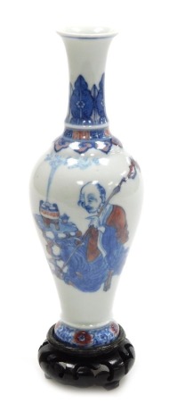 A 20thC Chinese porcelain vase, of slender baluster form, decorated in blue and iron red, with a seated deity, beneath ruyi and lappet borders, four character Yongzheng mark to base, on stand, 20cm high.