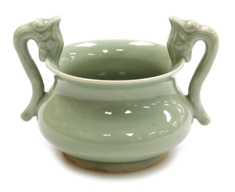 A Chinese Longquan celadon twin handled porcelain censer, of baluster form, with figural handles, 15cm wide.