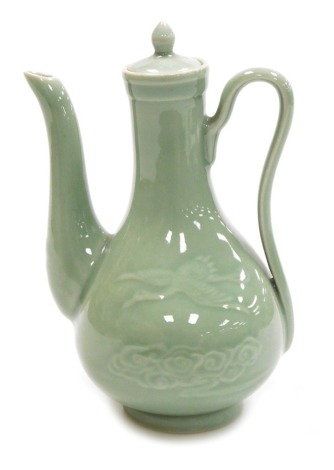 A Chinese celadon glazed ewer and cover, of pear shape, the body incised with cranes and clouds, 21.5cm high.