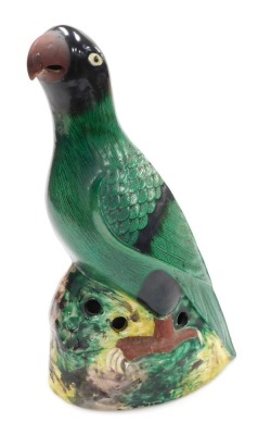 A 20thC Chinese pottery figure of a parrot, green glazed, on a naturalistic ground, with holes to the sides of the base, 36.5cm high.