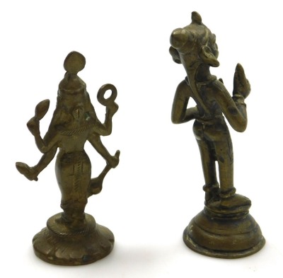 A Sri Lankan brass figure of Buddha, modelled in standing pose, raised on a waisted circular base, 25cm high, and four further brass figures of deities. (5) - 8