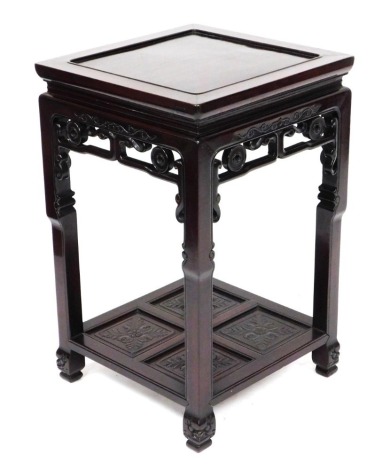 A late 19thC Chinese rosewood urn stand, the square top with recessed centre, with open stylised scroll gallery below and square shaped legs with undershelf of four flower head and foliage panels. 48cm high, 48 cm wide, 76cm long.