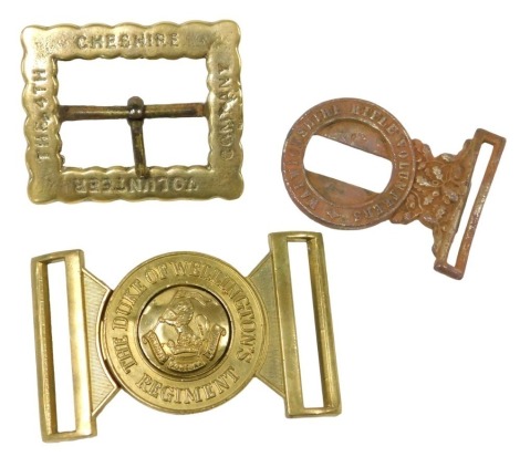 A British Army regimental brass belt buckle, for the Duke of Wellington's Regiment, with central regimental crested boss, stamped 051 to the reverse, a part steel belt buckle for the Warwickshire Rifle Volunteers, and a reproduction brass belt buckle for 