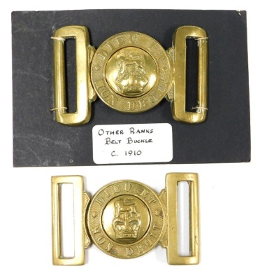 Two British Army brass belt buckles, each inscribed Dieu et Mon Droit, with central crown and lion surmount boss.