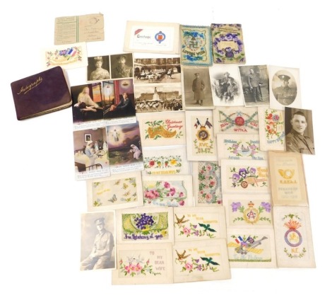 A collection of First World War silk postcards and others, including photographic portrait postcards of WWI soldiers and other related postcards, and an autograph book. (approx 30)