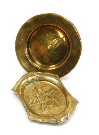 A WWI brass embossed tray, with infantryman and flag within wreath border, 17cm, and a brass circular dish bearing the regimental crest of the Queen's Own Cameron Highlanders, 15cm diameter.