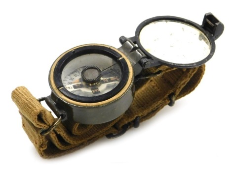 A British Army wrist compass, reference number 6B/2593, serial number 130688/58, with broad arrow mark, on canvas webbing strap.