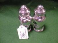 A pair of silver pepper pots