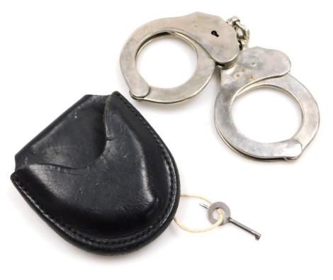 A pair of Spanish Alcyon handcuffs, with key and leather pouch case.