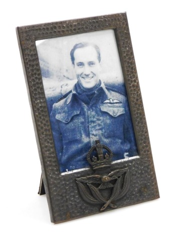 A WWII period New Zealand Air Force photograph frame, of beaten metal design with crowned spread eagle and fern crest, easel back, aperture measures 18cm x 8cm.