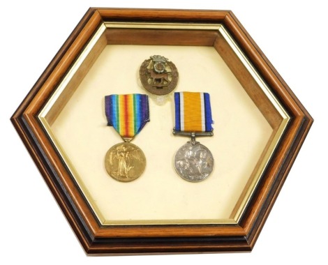 A WWI medal pair, inscribed to 31296 Pte AG Hardy, Yorkshire and Lancashire Regiment, comprising 1914-1918 British War medal and Victory medal, and mounted together with York and Lancaster Regimental cap badge (framed).