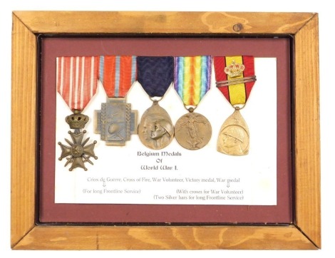 A group of WWI Belgium medals, comprising Criox de Guerre, Cross of Fire, War Volunteer, Victory medal, and War medal with two bars and crown, mounted and framed.