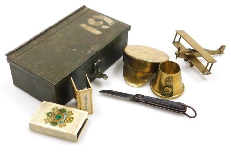 A British Army military steel box, etc., including brass model of a biplane, a trench craft shell cap inscribed War Menin 1914-19 souvenir, two matchbox holders, etc.