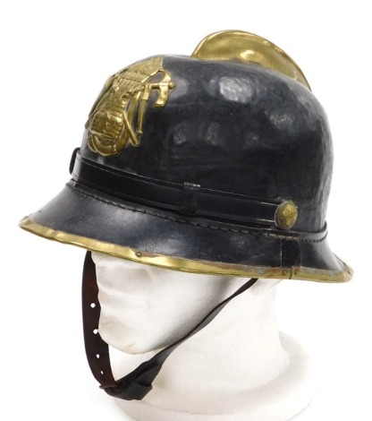 An early 20thC Portuguese leather and brass fireman's helmet by Bombeiro, with crest badge and brass rim, with Bombeiro named bosses to the leather strap.