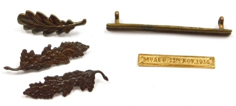 Three bronze Mentioned in Dispatches oak leaf insignia, (two versions), etc., and a WWI gilt metal wound stripe and a medal ribbon clasp for 5th Aug - 22nd November 1914.