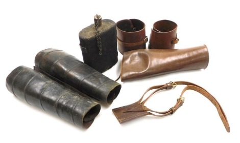 A British Army WWI water bottle, with felt cover, leather gaiters, officer's leather bayonet frog, etc.