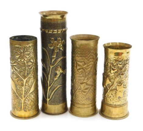 A WWI brass ordnance shell cases, each with trench art decoration, of ivy and floral designs, the tallest 30cm.