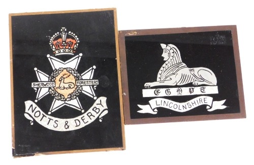 Two verre eglomise and foil regimental crests, for the Lincolnshire Regiment, 20cm x 25cm, and the Notts & Derby Sherwood Foresters, 30cm x 23cm.