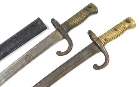 A French 1866 pattern Chassepot bayonet, with Yataghan blade, the back engraved St Etienne 1871, with scabbard, blade measures 57cm and another similar bayonet for St Etienne, indistinctly engraved, lacking scabbard. (2)