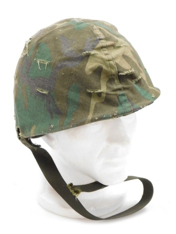 A US M1 pattern steel helmet, with liner, strap and camouflage cover, the helmet hand painted with the word 'tank'.