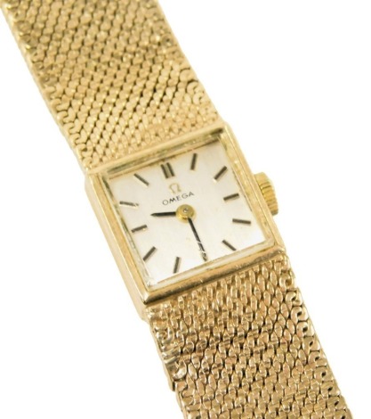 An Omega lady's 9ct gold case wristwatch, square silvered dial with batons, on a 9ct gold strap with snap clasp, 33g all in.