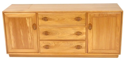 An Ercol light elm sideboard, with three central drawers, flanked by two cupboard doors, raised on a plinth base, 68cm high, 155cm wide, 43.5cm deep.