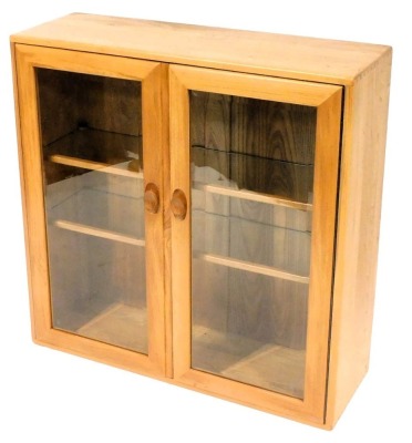 An Ercol light elm display cabinet, with two glazed doors enclosing two shelves, 92cm high, 91cm wide, 30.5cm deep.