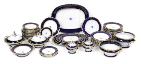 A late 19thC Davenport pottery dinner service, each bearing a crest, within a cobalt blue border, gilt heightened, bears registration mark, impressed and printed marks, comprising six graduated meat platters, soup tureen, three vegetable tureens, and two 