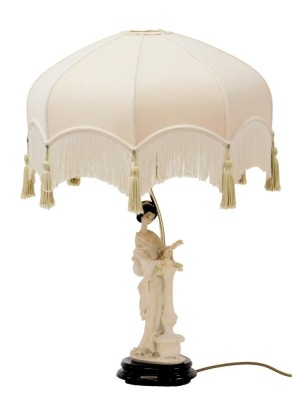 A Giuseppe Armani Capodimonte figural table lamp, modelled as a Geisha girl standing against a vase of flowers, on a wooden base, with shade, 69cm high.