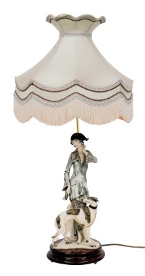 A Giuseppe Armani Capodimonte figural table lamp, modelled as a 1920s lady, with a hound, on wooden base, limited edition 2541/5000, with shade, with certificate, 89cm high.