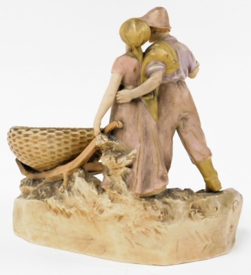 A Royal Dux blush porcelain figural bowl, modelled as a man alongside a lady pushing a wheelbarrow, raised on a naturalistic base, number 235, impressed and raised triangle marks, 29cm wide. - 2