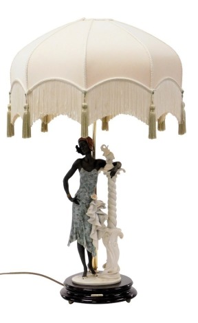 A Giuseppe Armani Capodimonte figural table lamp, modelled as an Art Deco lady standing against a stylised column, raised on an oval base, with shade, limited edition 1740/5000, 78cm high.