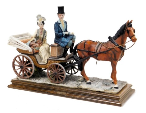 A Capodimonte porcelain figure group, designed by A Belcari, modelled as a woman in a horse drawn carriage, raised on a wooden base, 49cm wide.