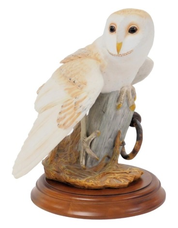 A Franklin Mint porcelain figure of The Barn Owl, designed by George McMonigle, on a wooden stand, with certificate, figure 26cm high.