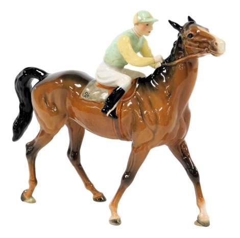 A Beswick pottery figure of a racehorse and jockey, number 24, the rider in yellow and pale green colours, printed mark, 25cm wide.