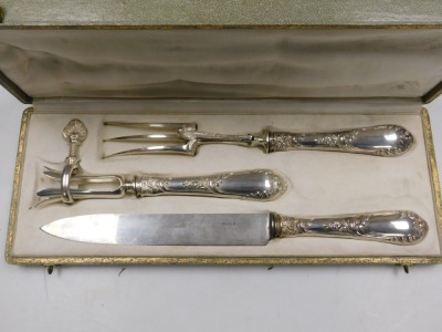 An early 20thC French silver handled carving set, with embossed floral and foliate decoration, comprising a fork, knife, and hand brace, cased, bears marks. - 2