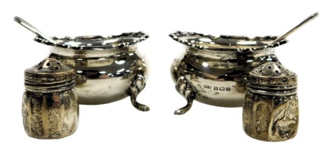 A pair of George V silver salts, raised on four paw feet, together with salt spoons, Birmingham 1912, and two pepperettes of reeded circular form, stamped sterling, 3.22oz.