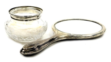 A cut glass jar with silver mount, hallmarks worn, and a George V silver backed hand mirror, Birmingham 1917. (2)