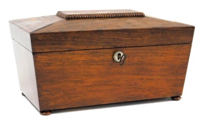 A Regency rosewood tea caddy, of sarcophagus form, with mother of pearl key escutcheon, the hinged lid opening to reveal two lidded compartments flanking a central recess with glass mixing bowl, raised on bun feet, 16cm high, 30cm wide, 15.5cm deep.