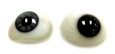 Two Victorian glass prosthetic eyes, one with a grey iris, the other brown.