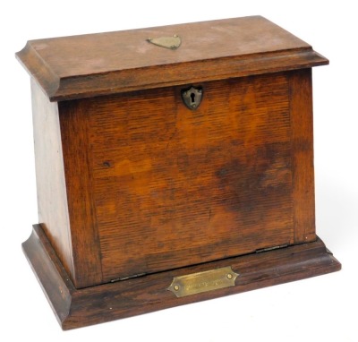 A Victorian oak stationary rack, the lid with a monogrammed brass shield escutcheon, and drop front, both opening to reveal a fitted interior, raised on a plinth base, with brass presentation plaque, 26cm high, 34cm wide, 18.5cm deep. - 2