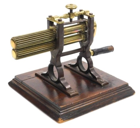 A Victorian brass and cast iron collar crimping machine, with a turned lignum vitae handle, raised on an oak base, 34.5cm wide.