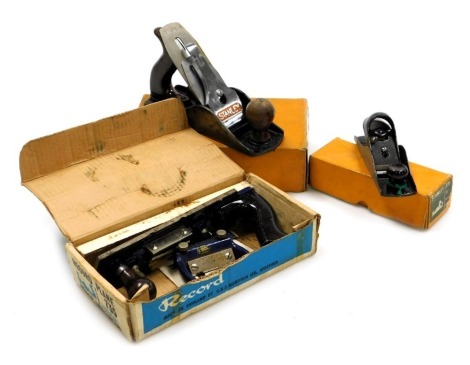 A Stanley number 220 block plane, Stanley 4.5 smoothing plane, and a Record number 735 fibre board plane, all boxed. (3)