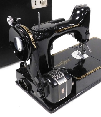 A Singer electric sewing machine, 221K, boxed with accoutrements. Buyer Note: WARNING! This lot contains untested or unsafe electrical items. It is supplied for scrap or reconditioning only. TRADE ONLY - 3