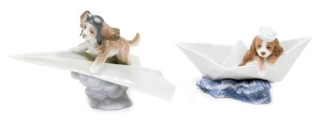 A Lladro porcelain figure of a puppy sitting in a paper boat, and another of a puppy riding a paper aeroplane. (2)