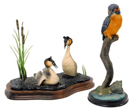 A Border Fine Arts sculpture modelled as Great Crested Grebes, circa 1985, on a wooden stand, and a further sculpture unnamed, of a kingfisher, 29cm high. (AF)